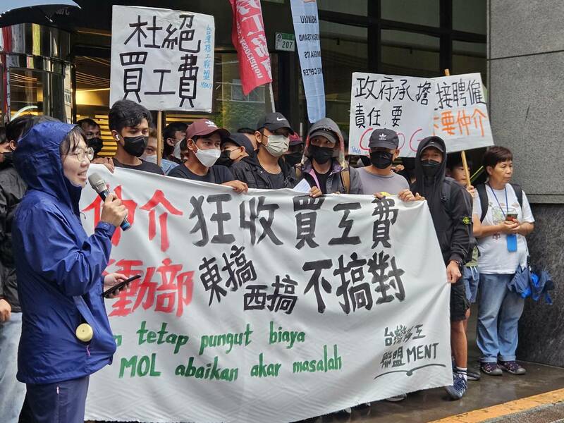 台灣國際勞工協會與近50位移工大雨中在勞動部門口抗議,抗議移工遭仲介收高額買工費,盼儘速研擬廢除仲介。(Photo by 呂翔禾/台灣醒報)